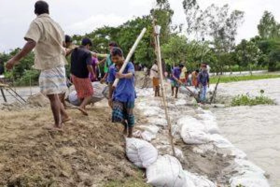 Locals taking care of a dam to protect Lalmonirhat town from the devastating floods on Wednesday DHAKA TRIBUNE 