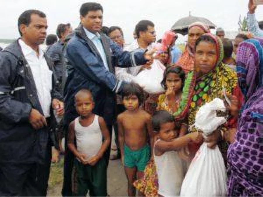 Lalmonirhat Deputy Commissioner Abul Fazal Mohammad Alauddin Khan, accompanied bym others, distributing relief goods among flood-affected people in Hatibandha upazila of the district on Wednesday DHAKA TRIBUNE