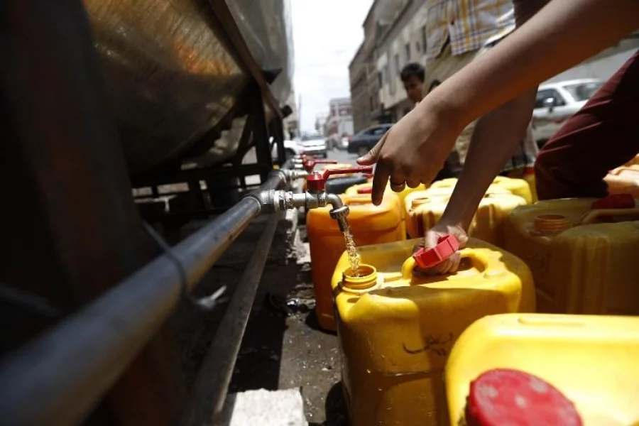 A close up shot shows the hand of a Yemeni youth filling a jerrycan with safe drinking water from a donated water-tank in the capital Sanaa on July 2, 2017. The collapse of Yemen's infrastructure after more than two years of war between the Saudi-backed government and Shiite rebels who control the capital has made for a "perfect storm for cholera," the WHO's senior emergency adviser for Yemen, Ahmed Zouiten, said.  / AFP PHOTO / Mohammed HUWAIS