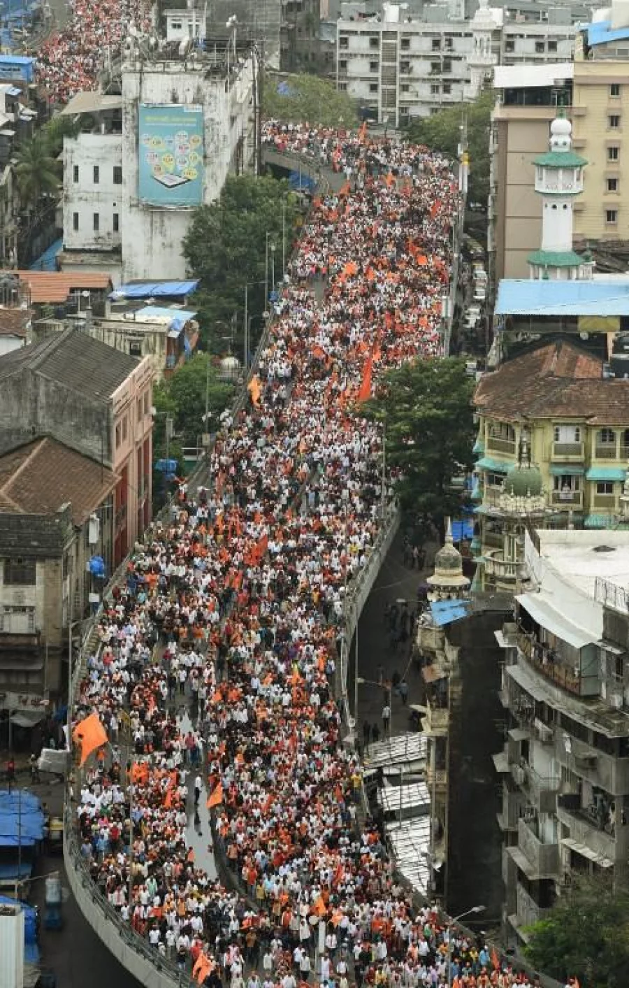 Indian members of the Maratha community in the state of Maharashtra cross a flyover as they take part in a rally in Mumbai on August 9, 2017. The Maratha Kranti Morcha silent protest is being held to demand emplyoment quotas for the Maratha in state-run education institutions and government jobs, a minimum support price for farm produce, and amendments to the Scheduled Castes and Scheduled Tribes (Prevention of Atrocities) Act. / AFP PHOTO / PUNIT PARANJPE