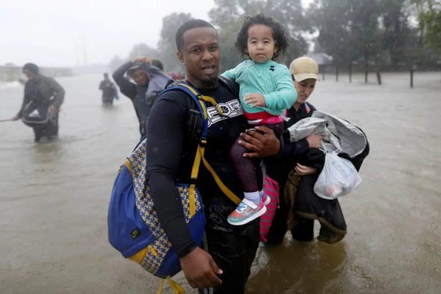 Isiah Courtney and his one-year-old daughter Aubry wade through flood waters in Beaumont Place, Houston | Reuters